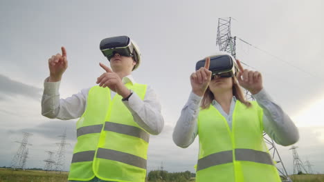 Two-engineers-of-power-engineers-in-VR-glasses-move-their-hands-simulating-the-operation-of-the-interface-of-the-control-system-and-planning-of-high-voltage-lines-for-the-delivery-of-electricity-from-alternative-energy-sources.
