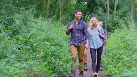 Mature-And-Mid-Adult-Couples-In-Countryside-Hiking-Along-Path-Through-Forest-Together