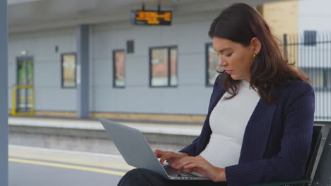 Mujer-De-Negocios-Viajando-Al-Trabajo-Esperando-El-Tren-En-La-Plataforma-De-La-Estación-Trabajando-En-Una-Computadora-Portátil
