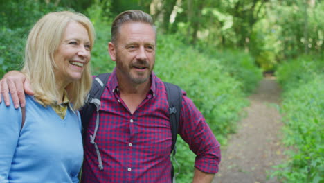 Mature-Couple-In-Countryside-Hiking-Along-Path-Through-Forest-Together