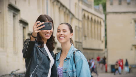 Glückliches-Gleichgeschlechtliches-Weibliches-Paar-Beim-Sightseeing,-Während-Sie-Für-Ein-Selfie-Posieren-Und-Gemeinsam-Durch-Oxford,-Großbritannien,-Spazieren