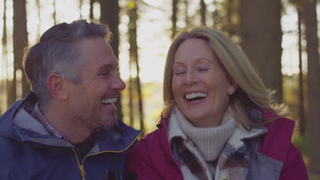 Head-and-shoulders-shot-of-laughing-mature-couple-on-walk-through-fall-or-winter-countryside---shot-in-slow-motion