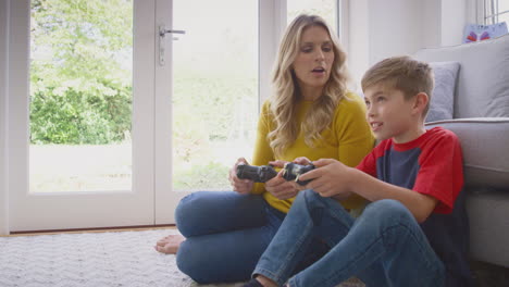 Mother-And-Son-At-Home-Playing-Video-Game-Together-With-Boy-Celebrating-When-He-Wins