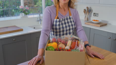 Portrait-of-woman-unpacking-online-meal-food-recipe-kit-delivered-to-home---shot-in-slow-motion