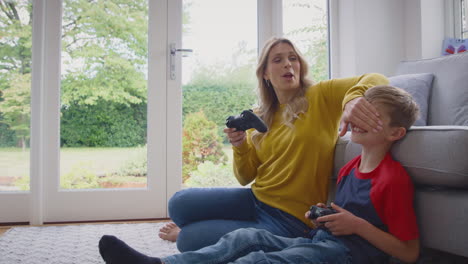 Mother-And-Son-At-Home-Playing-Video-Game-Together-With-Woman-Cheating-To-Win