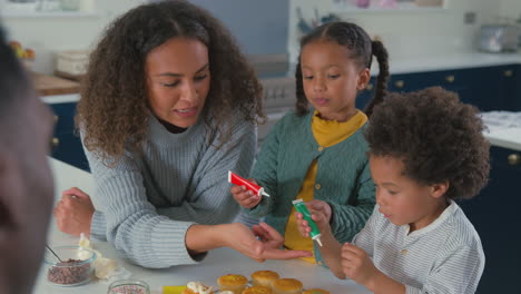 Familie-Mit-Kindern-In-Der-Küche,-Die-Gemeinsam-Cupcakes-Dekorieren