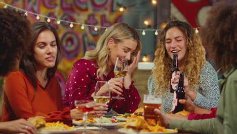 Multi-Cultural-Group-Of-Friends-Enjoying-Night-Out-Eating-Meal-And-Drinking-In-Restaurant-Together