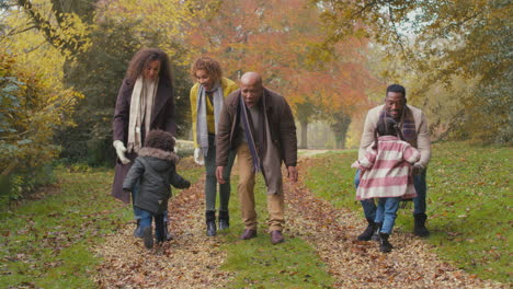 Smiling-Multi-Generation-Family-Having-Fun-With-Children-Walking-Through-Autumn-Countryside-Together
