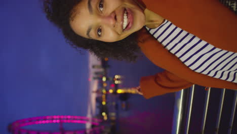 Vertical-video-of-woman-recording-video-vlog-of-herself-next-to-the-London-Eye-at-might---shot-in-slow-motion