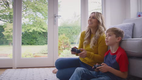 Mother-And-Son-At-Home-Playing-Video-Game-Together-With-Woman-Celebrating-When-She-Wins