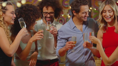 Multi-Cultural-Group-Of-Friends-Celebrating-Making-Toast-Enjoying-Party-Night-Out-In-Bar-Or-Club