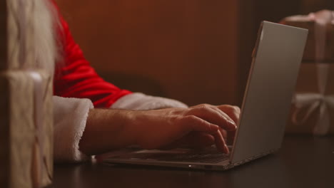 Santa-Claus-answers-the-child's-email.-Typing-on-the-laptop-keyboard.-Santa-Claus-hands-close-up.-High-quality-4k-footage