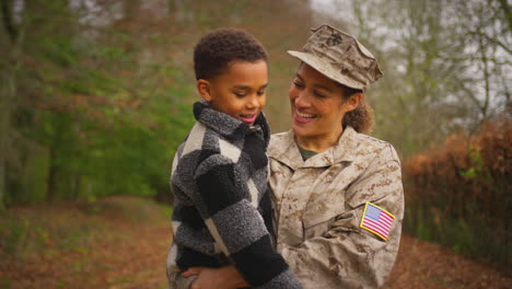Mujer-Soldado-Estadounidense-Regresando-A-Casa-Con-Su-Familia-De-Permiso-Llevando-A-Su-Hijo-En-Brazos
