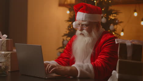 Lustiger-Weihnachtsmann,-Der-An-Einem-Laptop-Computer-Arbeitet.-Weihnachtsmann-Mit-Laptop-Nahaufnahme.-Hochwertiges-4K-Filmmaterial