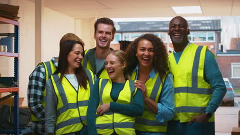 Portrait-Of-Multi-Cultural-Team-Wearing-Hi-Vis-Safety-Clothing-Working-In-Modern-Warehouse