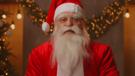 Kopfschuss-Mit-Blick-In-Die-Kamera,-Glücklicher-Alter-Bärtiger-Weihnachtsmann-Im-Kostüm-Und-Winkender-Hand,-Videoanruf-In-Zoom-Aufnahmevideo,-Frohe-Weihnachtsgrüße,-Gesichtskameraansicht,-Hochwertiges-4K-Filmmaterial