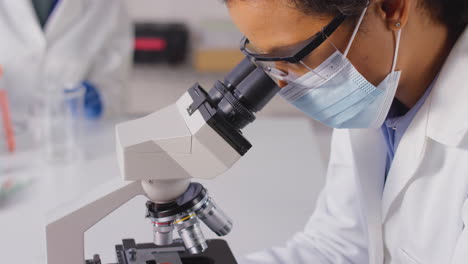 Nahaufnahme-Einer-Laborantin-Oder-Phlebotomistin,-Die-Blutproben-Im-Labor-Mit-Einem-Mikroskop-Analysiert