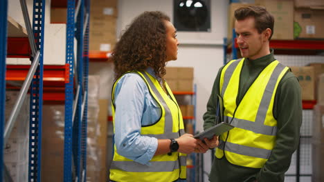Male-And-Female-Workers-With-Digital-Tablet-In-Warehouse-Meeting-And-Talking-By-Shelves