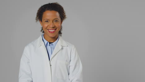Studio-Portrait-Of-Smiling-Female-Doctor-Or-Lab-Worker-Wearing-White-Coat