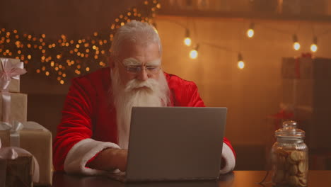 Jolly-Santa-working-on-a-laptop-computer.-Santa-Clause-using-laptop-close-up.-High-quality-4k-footage