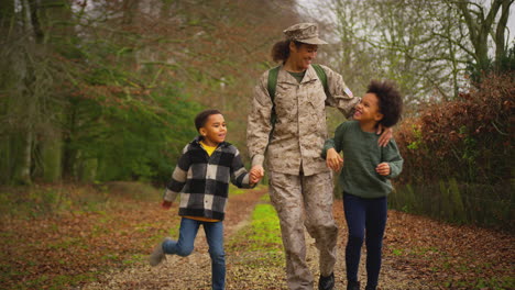 Mujer-Soldado-Estadounidense-Regresando-A-Casa-Con-Permiso-Para-Ir-A-Su-Familia-Caminando-Con-Dos-Niños-Tomados-De-La-Mano