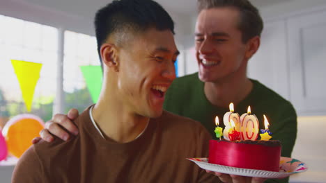 Same-Sex-Male-Couple-Celebrating-30th-Birthday-At-Home-With-Cake-And-Presents