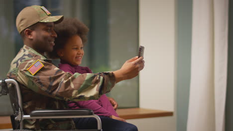 Injured-American-Soldier-Wearing-Uniform-In-Wheelchair-Posing-For-Selfie-On-Phone-With-Daughter