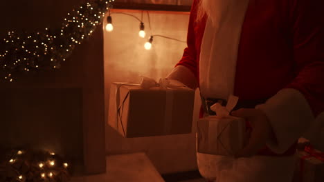 Nahaufnahme-Der-Hand-Des-Weihnachtsmanns:-Er-Bringt-Den-Kindern-Geschenke-Unter-Den-Weihnachtsbaum.-In-Der-Weihnachtsnacht-Schenkt-Er-Den-Kindern-Geschenke.-Der-Weihnachtsmann-Legt-Ein-Geschenk-Unter-Den-Weihnachtsbaum.-Hochwertiges-4K-Filmmaterial