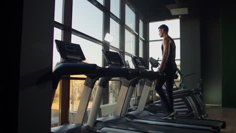 Young-athletic-men-and-women-exercising-and-walk-on-treadmill-in-sport-gym.-Slow-motion