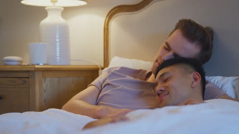 Loving-Same-Sex-Male-Couple-Lying-In-Bed-At-Home-Asleep