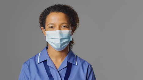 Studio-Portrait-Of-Female-Nurse-Wearing-Uniform-And-Face-Mask
