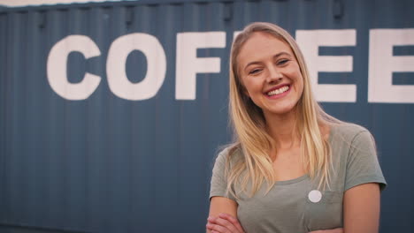 Portrait-Of-Smiling-Female-Intern-At-Freight-Haulage-Business-Standing-By-Shipping-Container