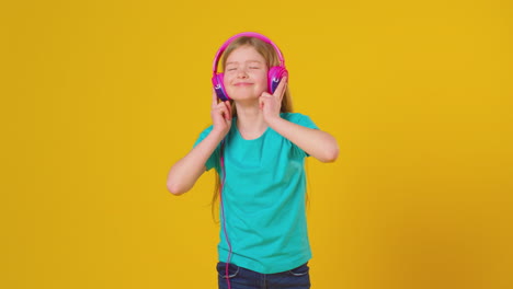 Studioporträt-Eines-Mädchens-Mit-Kopfhörern,-Das-Musik-Vor-Gelbem-Hintergrund-Streamt