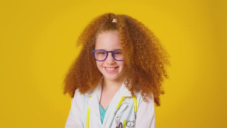 Studioporträt-Eines-Als-Arzt-Oder-Chirurg-Verkleideten-Mädchens-Mit-Stethoskop-Vor-Gelbem-Hintergrund