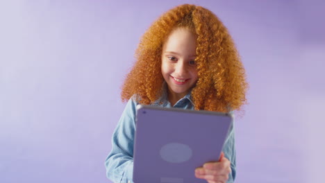 Studioporträt-Eines-Mädchens-Mit-Digitalem-Tablet-Vor-Violettem-Hintergrund