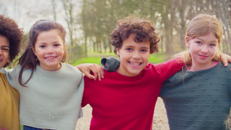 Portrait-Of-Children-Having-Fun-Playing-Outdoors-With-Arms-Around-Each-Other