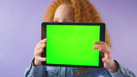 Studioporträt-Eines-Mädchens-Mit-Digitalem-Tablet-Mit-Grünem-Bildschirm-Vor-Violettem-Hintergrund