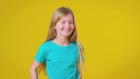 Studioporträt-Eines-Mädchens-Mit-Langen-Haaren,-Das-Vor-Gelbem-Hintergrund-Lacht