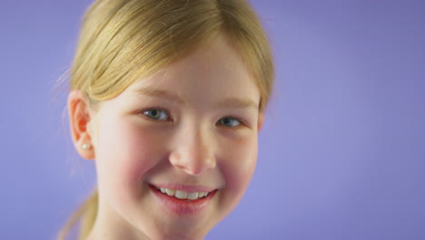 Studioporträt-Eines-Lächelnden-Mädchens-Mit-Langen-Haaren-Vor-Violettem-Hintergrund