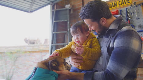 Vater-Mit-Down-Syndrom-Tochter-Streichelt-Hund-In-Heimwerkstatt