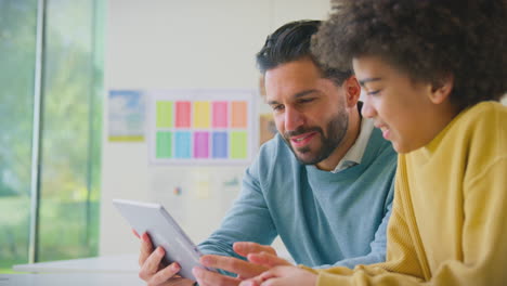 Lehrer-Und-Männlicher-Schüler-Im-Klassenzimmer-Nutzen-Gemeinsam-Ein-Digitales-Tablet