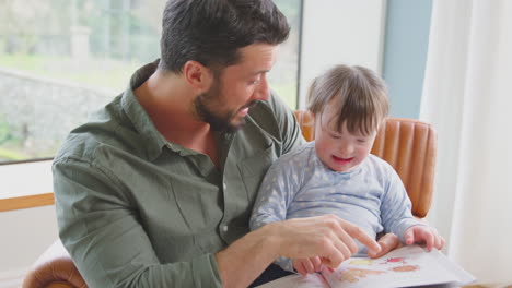 Vater-Mit-Down-Syndrom-Tochter-Liest-Zu-Hause-Gemeinsam-Ein-Buch