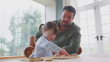 Vater-Mit-Down-Syndrom-Tochter-Spielt-Zu-Hause-Gemeinsam-Ein-Spiel-Mit-Holzformen