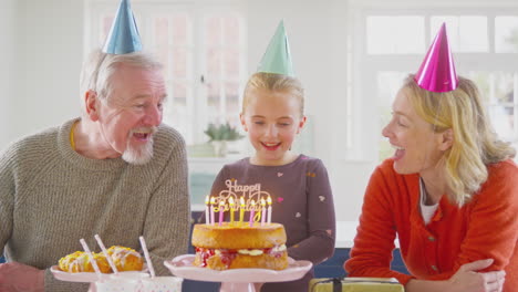 Grandparents-With-Granddaughter-Celebrating-Birthday-With-Party-At-Home-Together
