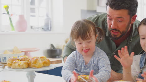 Vater-Mit-Down-Syndrom-Tochter-Backt-Und-Dekoriert-Kuchen-Und-Sitzt-Zu-Hause-Am-Tisch