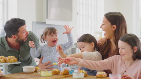 Familie-Mit-Down-Syndrom-Tochter-Backt-Und-Dekoriert-Kuchen-Und-Sitzt-Zu-Hause-Am-Tisch