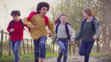 Portrait-Children-With-School-Backpacks-Outdoors-Running-Along-Countryside-Track