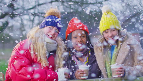 Portrait-Of-Teenage-Girls-Enjoying-Hot-Chocolate-On-Snowy-Winter-Walk-In-Countryside-Together