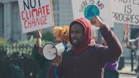 Gruppe-Von-Demonstranten-Mit-Plakaten-Und-Megafon-Auf-Demonstrationsmarsch-Gegen-Den-Klimawandel
