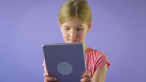 Studioporträt-Eines-Mädchens-Mit-Digitalem-Tablet-Vor-Violettem-Hintergrund